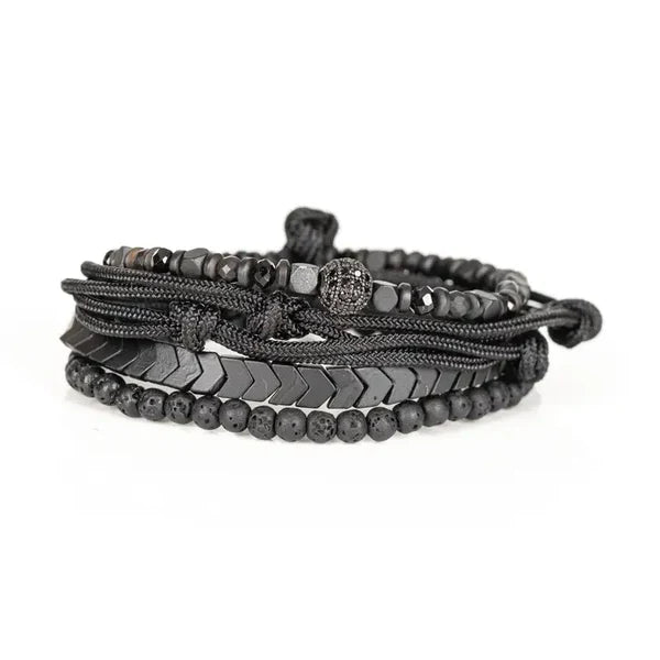 Black layered men’s bracelet with lava stone beads, hematite accents, braided cord, and adjustable closure on a white background.