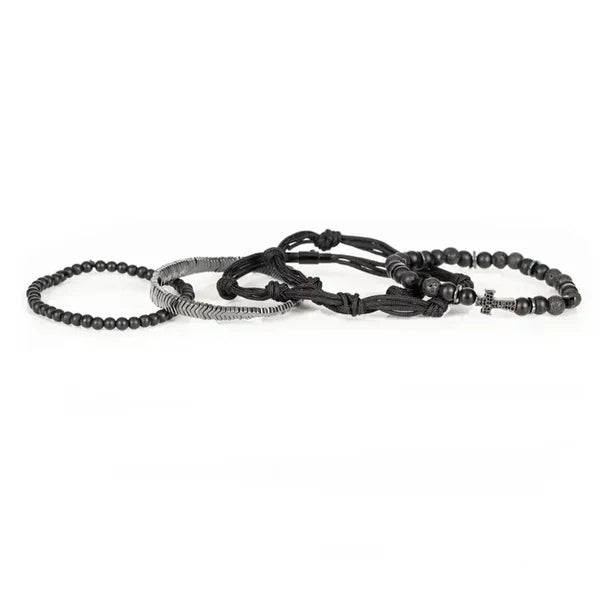 Black layered men’s bracelet with matte beads, braided cord knots, silver-tone chevron accents, and pavé cross centerpiece on a white background.