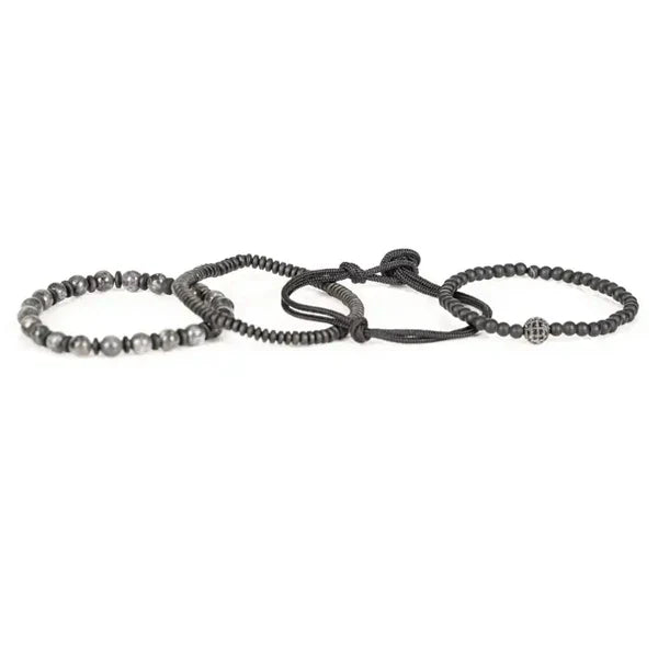 Men's layered black and gray beaded bracelet set featuring matte black beads, natural stone beads, hematite spacers, braided cord strands, and a pavé crystal accent bead in a modern luxury design.