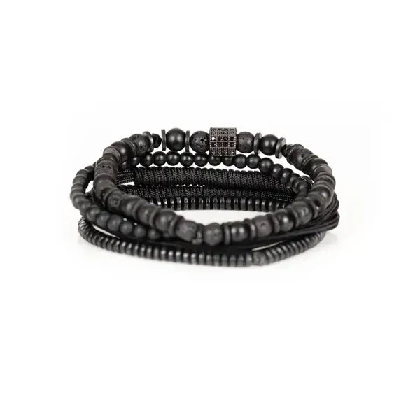 Men's layered black bracelet set featuring matte black beads, lava stone beads, hematite spacers, braided cord strands, and a black pavé cubic zirconia square centerpiece in a sleek modern luxury design.