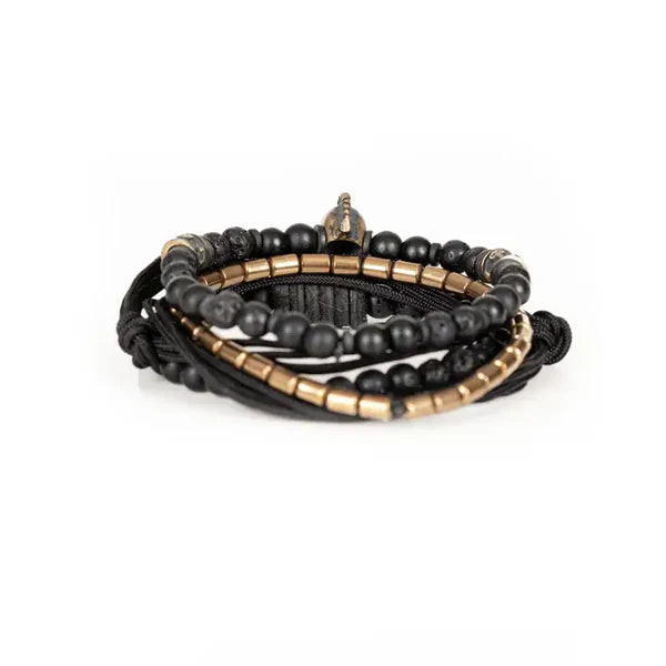 Black layered men’s bracelet with matte black beads, lava stone accents, braided cord wraps, bronze-tone metal beads, and a Spartan skull centerpiece on a white background.