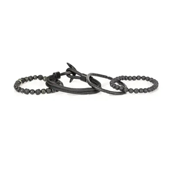 Layered men’s bracelet set featuring black lava stone beads, faceted black stone beads, braided black cord wraps, and metallic hematite accents in a monochromatic stacked design, displayed on a white background.
