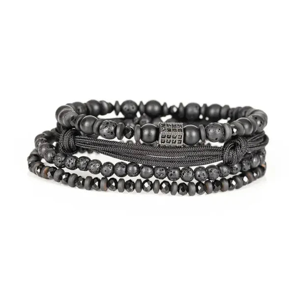 Men's layered black beaded bracelet set featuring matte black beads, lava stone beads, hematite spacers, braided cord strands, and a black pavé cubic zirconia accent bead for a modern luxury look.