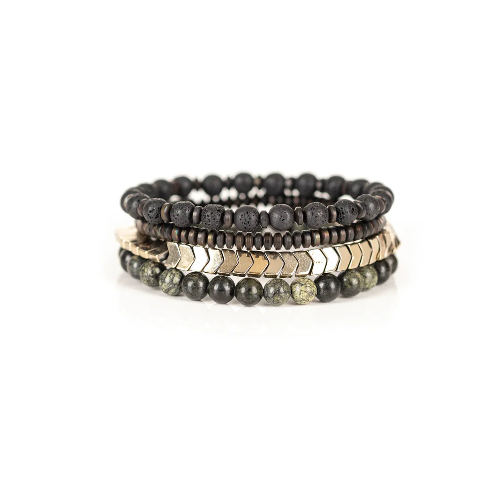 Men's handcrafted layered bracelet set featuring black lava stone beads, natural green serpentine gemstone beads, bronze hematite spacer beads, and gold hematite arrow-shaped beads. Premium stacked men's bracelet photographed on a clean white background.