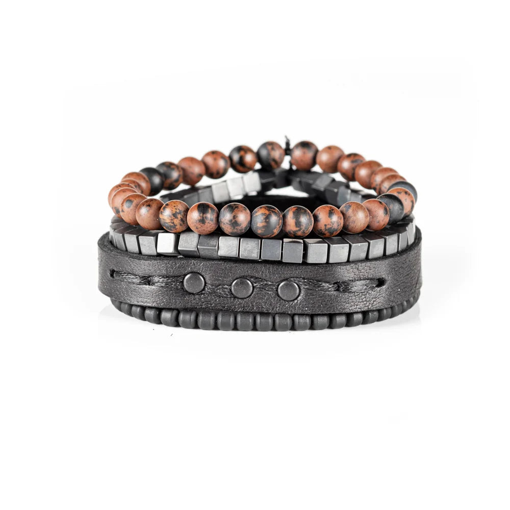 Men's handcrafted black leather wrap bracelet set featuring brown mahogany obsidian gemstone beads, matte black hematite cube beads, black seed beads, and a premium layered leather cuff with stitched detailing. Luxury men's bracelet stack photographed on a clean white background.