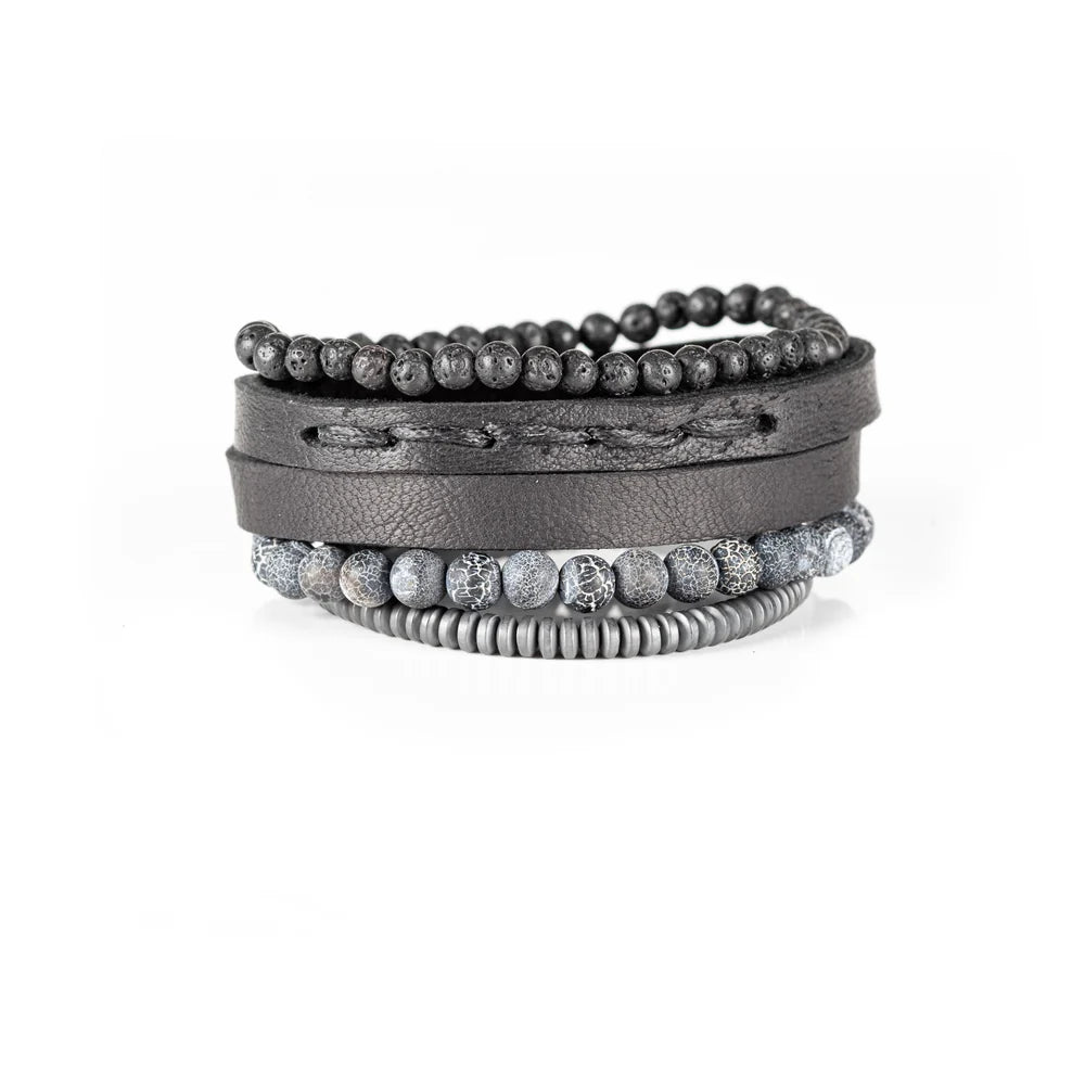 Men's handcrafted layered bracelet set featuring a black leather wrap cuff, black lava stone beads, natural gray crackle agate gemstone beads, matte gray heishi beads, and premium stitched leather detailing. Luxury men's stacked bracelet photographed on a clean white background.