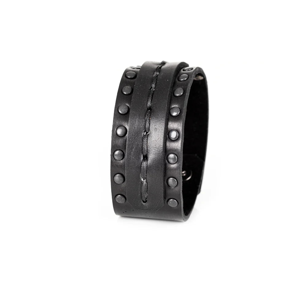Black genuine leather cuff bracelet with hand-stitched center strap and black metal stud detailing, handcrafted statement accessory on a white background.