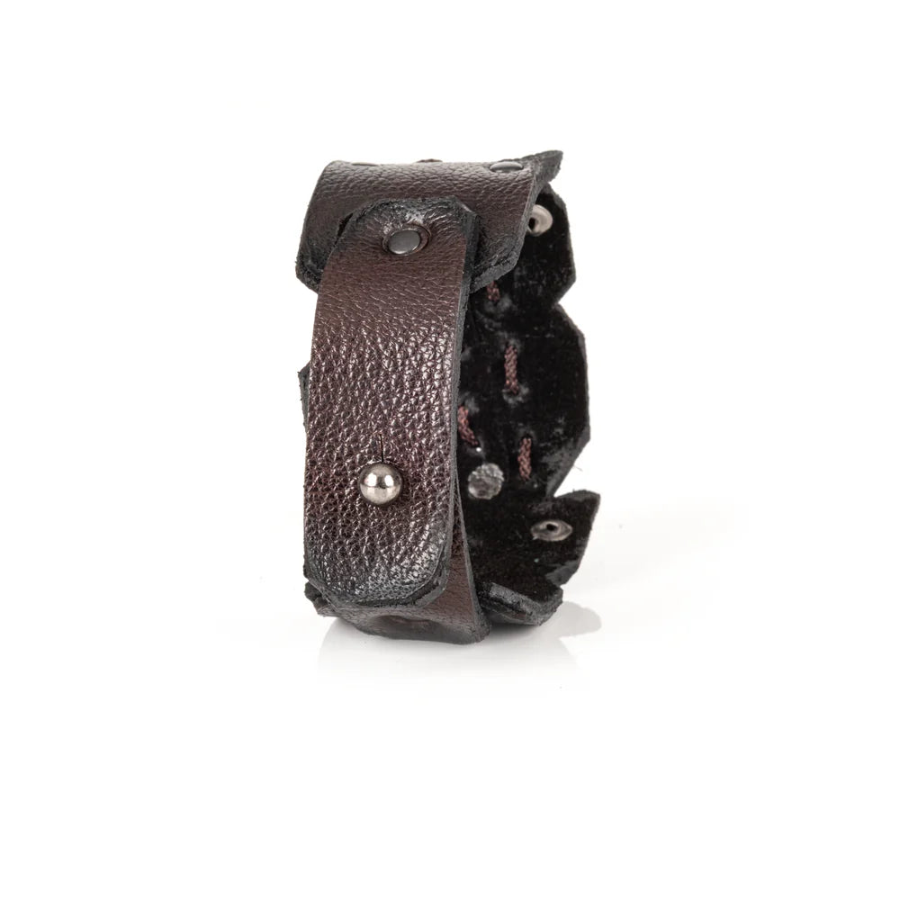 Black genuine leather cuff bracelet with hand-laced stitching, raw cut edges, and black rivet accents, handcrafted artisan statement accessory on a white background.