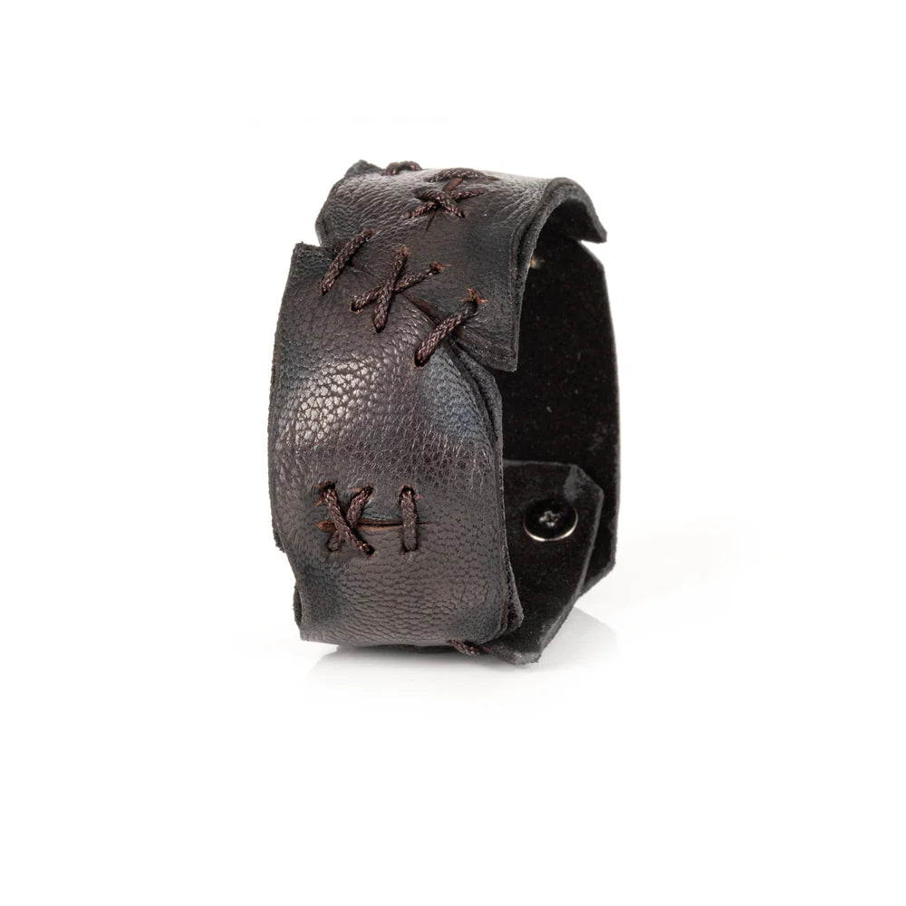 Black genuine leather cuff bracelet with hand-laced stitch detailing, raw cut edges, and a handcrafted artisan design, displayed on a white background.