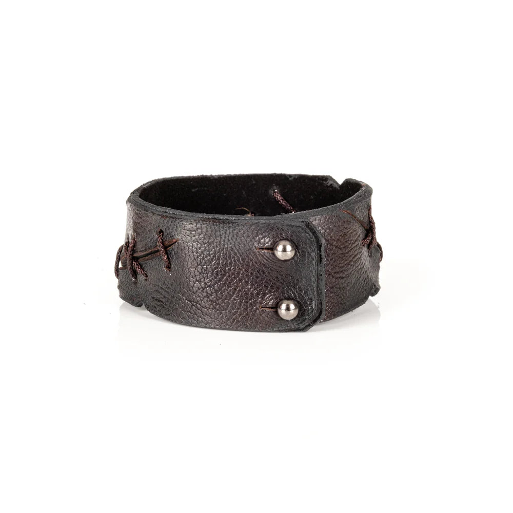 Black genuine leather cuff bracelet with handcrafted lace-up stitching details, rugged artisan finish, and a wide statement silhouette, displayed on a white background.