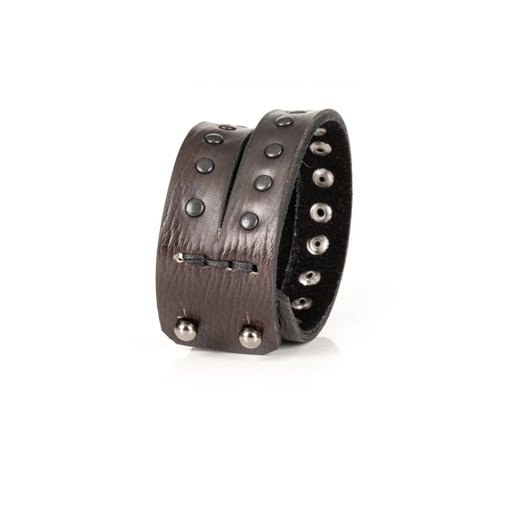 Black genuine leather wrap bracelet featuring double leather bands with black rivet detailing, handcrafted statement accessory with a rugged minimalist design, displayed on a white background.
