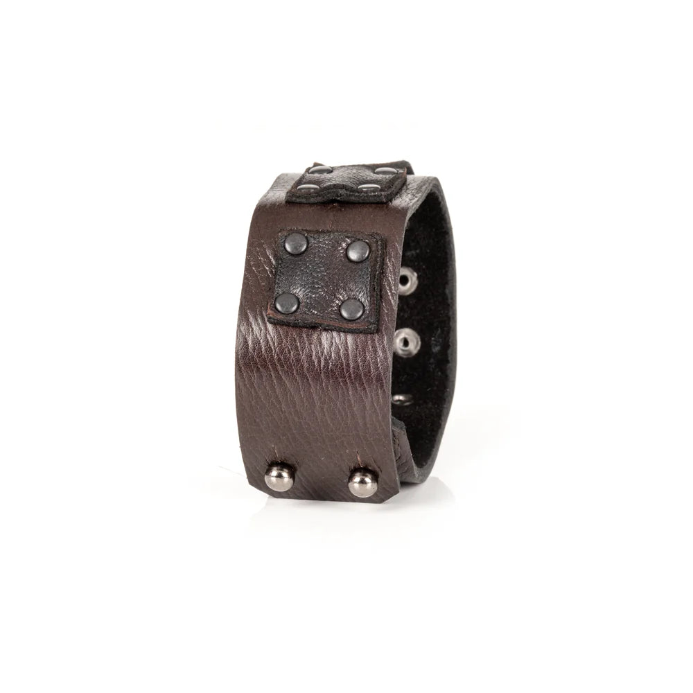 Black genuine leather cuff bracelet with layered square leather panels and black rivet detailing, handcrafted statement accessory with an industrial-inspired design, displayed on a white background.