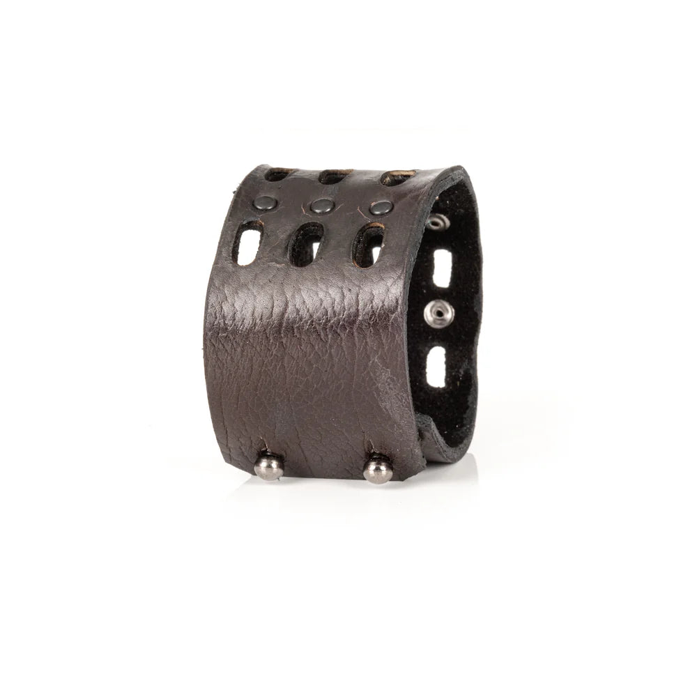 Black genuine leather cuff bracelet with perforated cutout detailing, black rivet accents, and a wide handcrafted statement design, displayed on a white background.