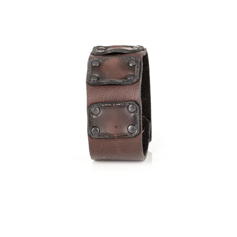 Men's handcrafted genuine leather cuff bracelet in dark brown featuring a wide minimalist design with layered leather panels, matte black rivet detailing, and premium artisan craftsmanship. Luxury men's leather wristband photographed on a clean white background.