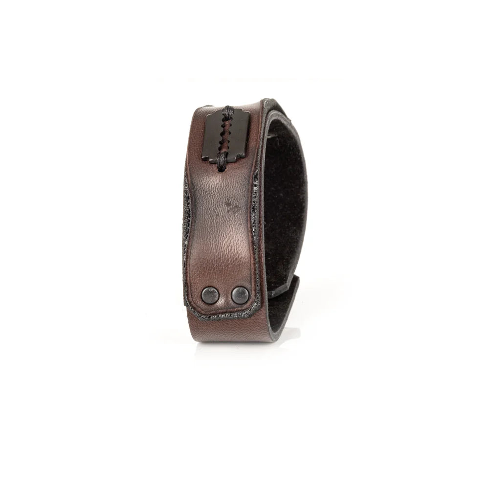 Men's handcrafted genuine leather cuff bracelet in dark brown featuring a wide minimalist design with black rivet hardware, hand-stitched razor blade accent, and premium artisan craftsmanship. Luxury men's leather wristband photographed on a clean white background.