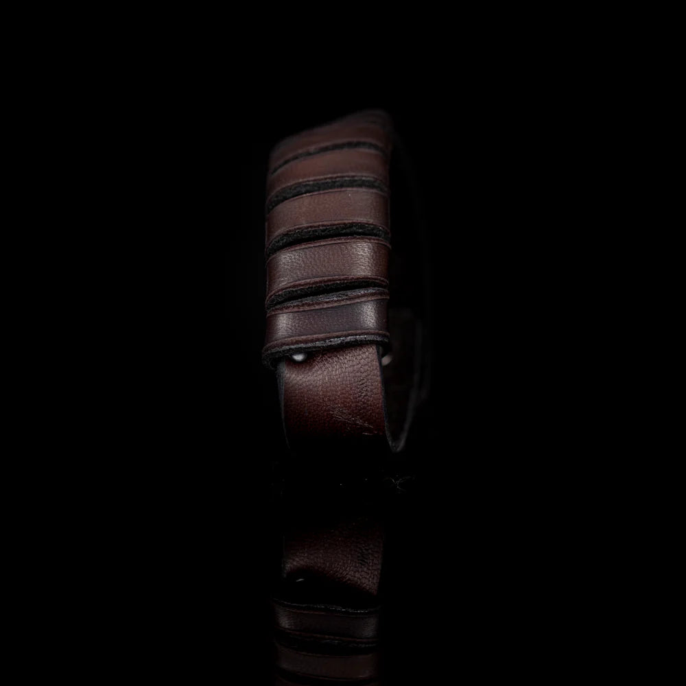 Men's handcrafted genuine leather cuff bracelet in dark brown featuring layered horizontal leather bands with a rugged stacked design and premium artisan craftsmanship. Luxury men's leather wristband photographed on a clean white background.