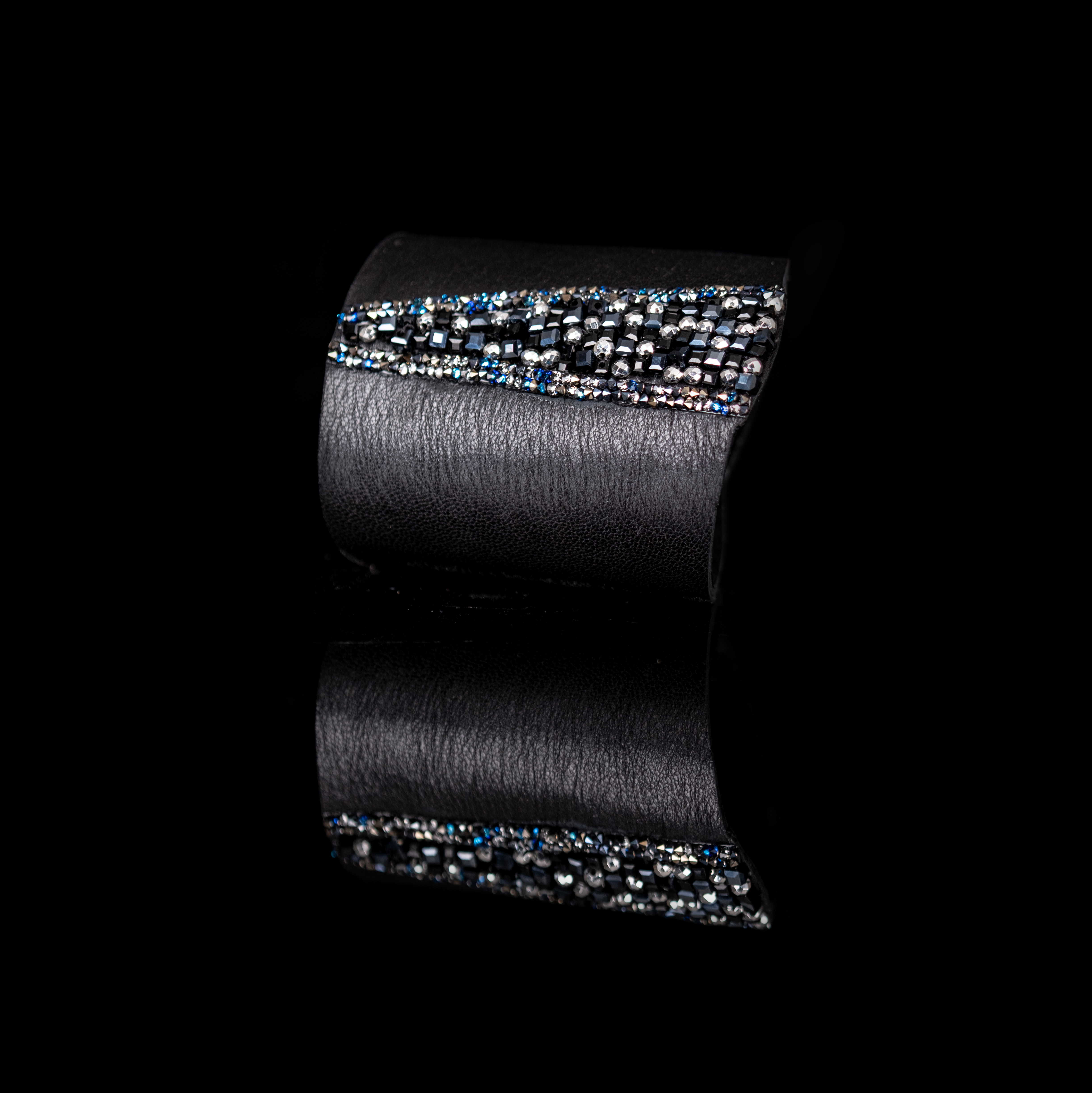 Black leather cuff bracelet with central stripe of black, silver, and blue crystals, handmade statement bracelet by THE DARK