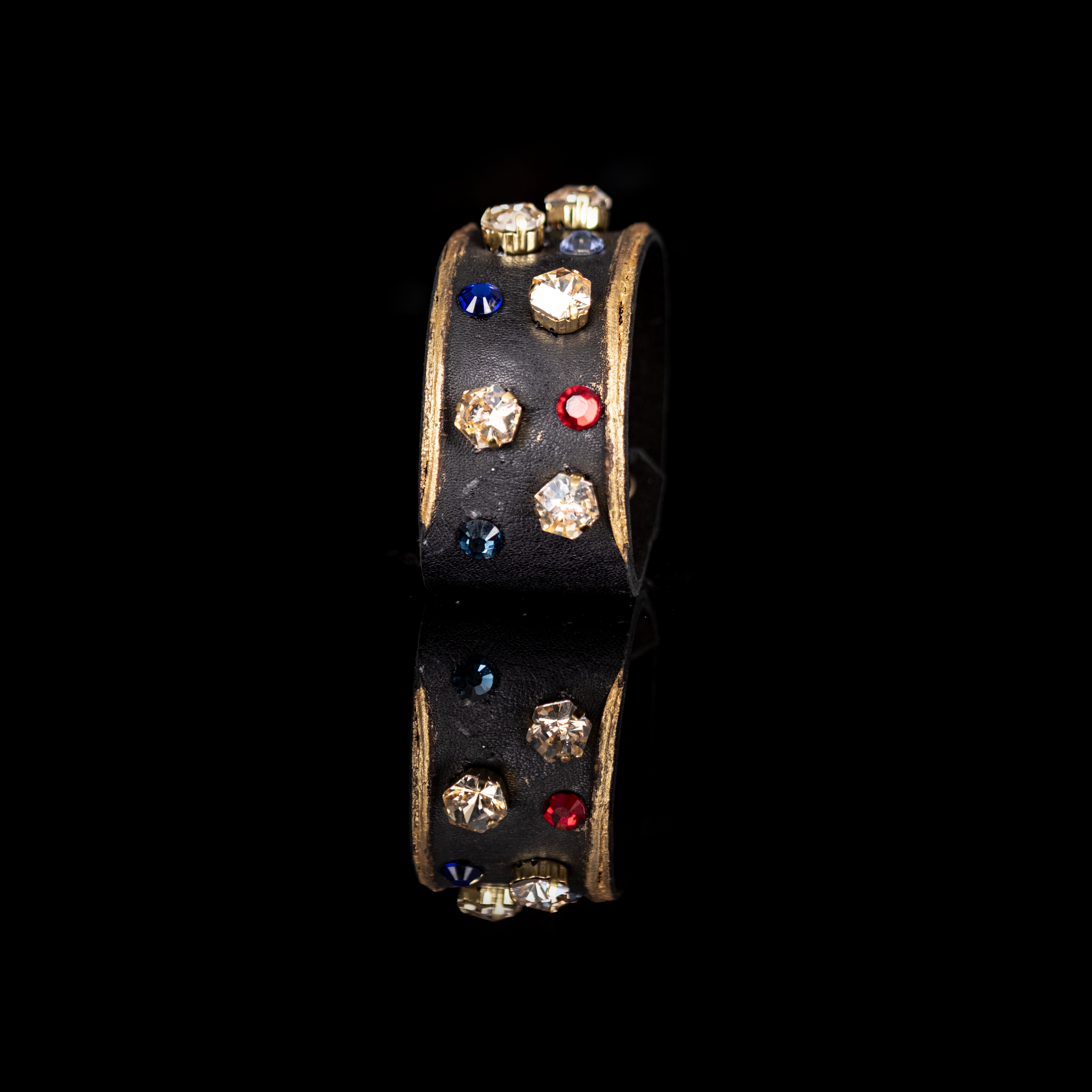 Black leather cuff with gold edges and scattered multicolor crystals, minimalist statement bracelet