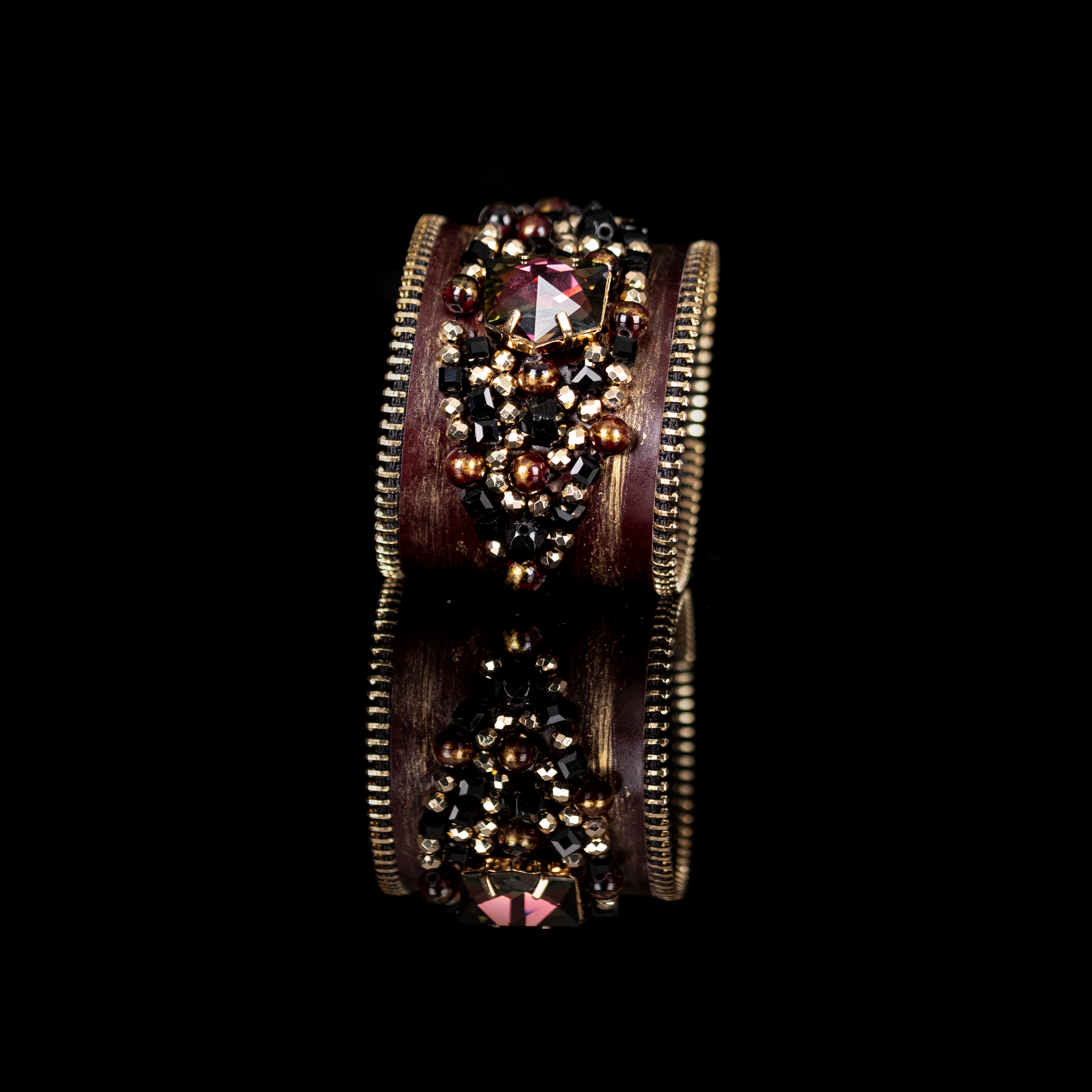 Dark leather cuff with gold brushed finish, zipper edges and black-gold crystal cluster centerpiece