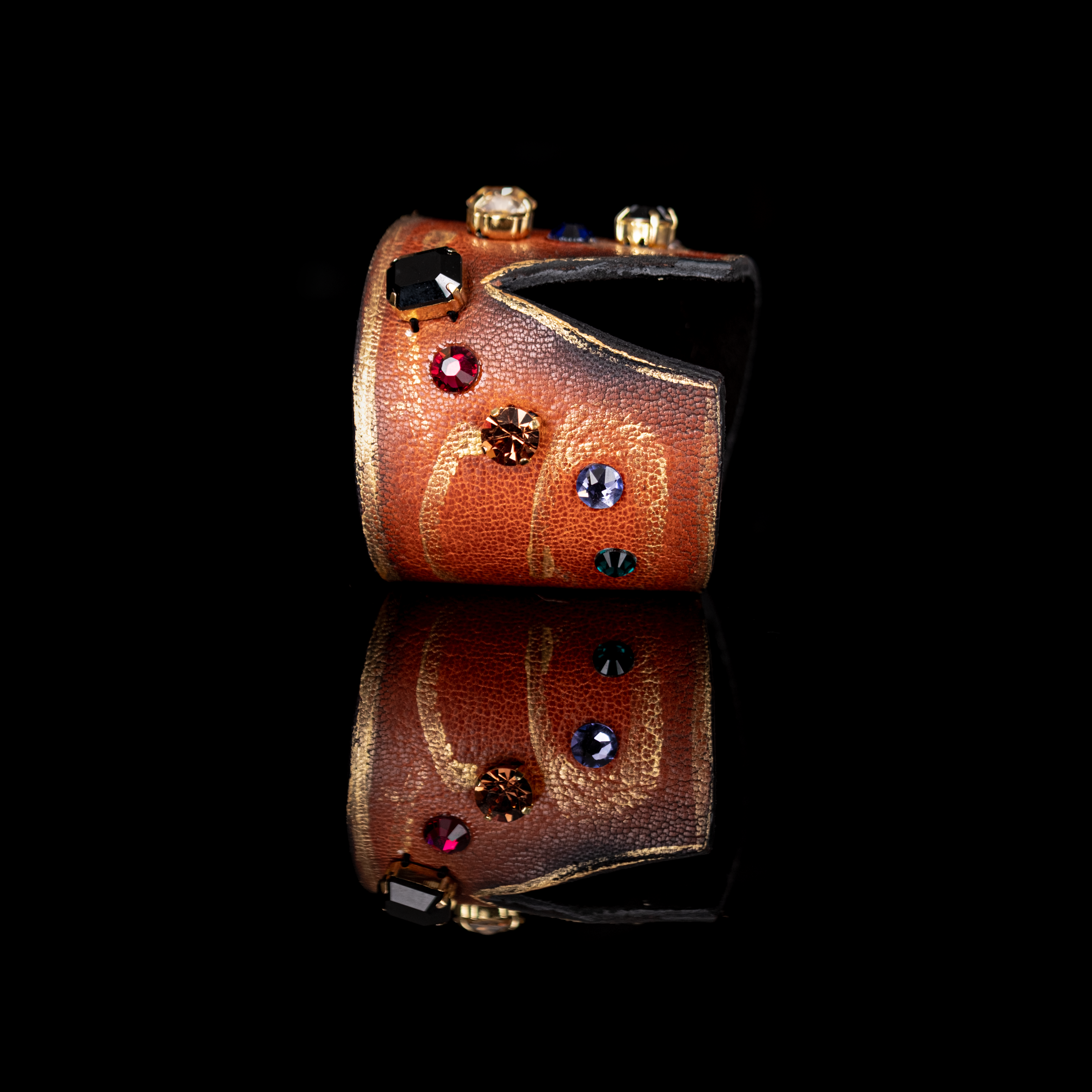 Copper-toned leather cuff bracelet with multicolor crystals and gold detailing