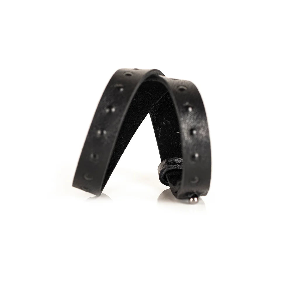 Black genuine leather wrap bracelet with embossed stud detailing and an adjustable strap closure, handcrafted minimalist accessory on a white background.