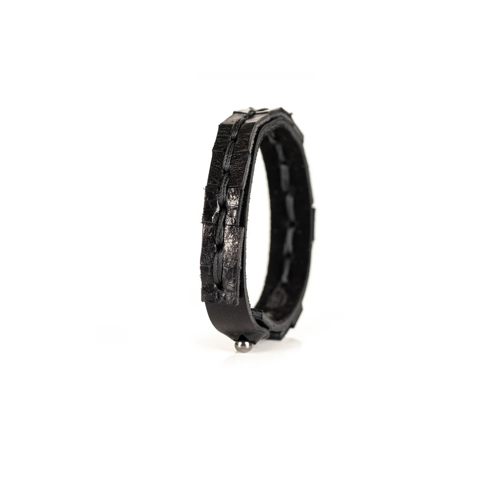 Black genuine leather bracelet featuring a hand-stitched center detail and geometric cut leather accents, handcrafted artisan accessory on a white background.