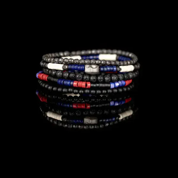 Layered men’s bracelet set featuring black matte beads, lava stone beads, faceted hematite beads, and red and blue accent beads with a silver-tone centerpiece, displayed on a white background.