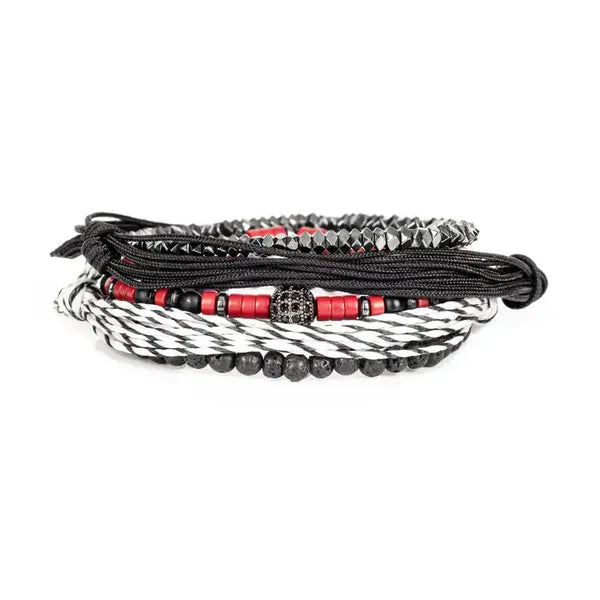Layered men’s bracelet set featuring black braided cord, red heishi beads, faceted hematite beads, black lava stone beads, a black-and-white woven bracelet, and a pavé crystal centerpiece, displayed on a white background.