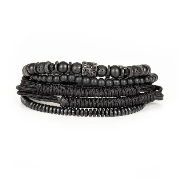 Men's layered black bracelet set featuring matte black beads, lava stone beads, hematite spacers, braided cord strands, and a black pavé cubic zirconia square centerpiece in a sleek modern luxury design.