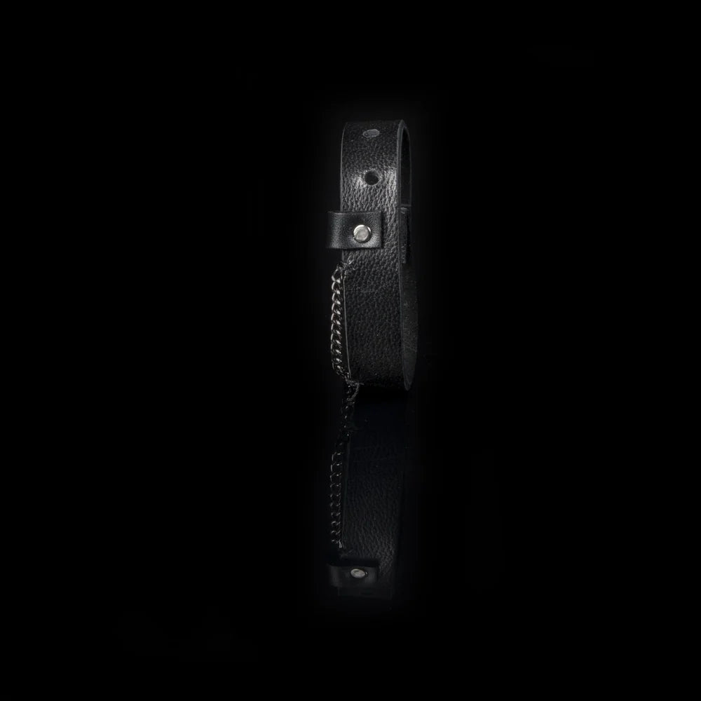 Men's black genuine leather cuff bracelet featuring a minimalist wide-band design with a gunmetal chain accent and snap-button closure, combining rugged style with modern sophistication.