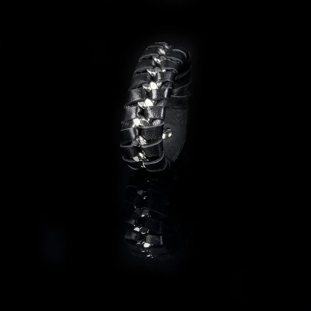 Men's black braided leather bracelet featuring an interwoven silver-tone chain accent, wide cuff design, and magnetic clasp closure for a bold contemporary luxury look.