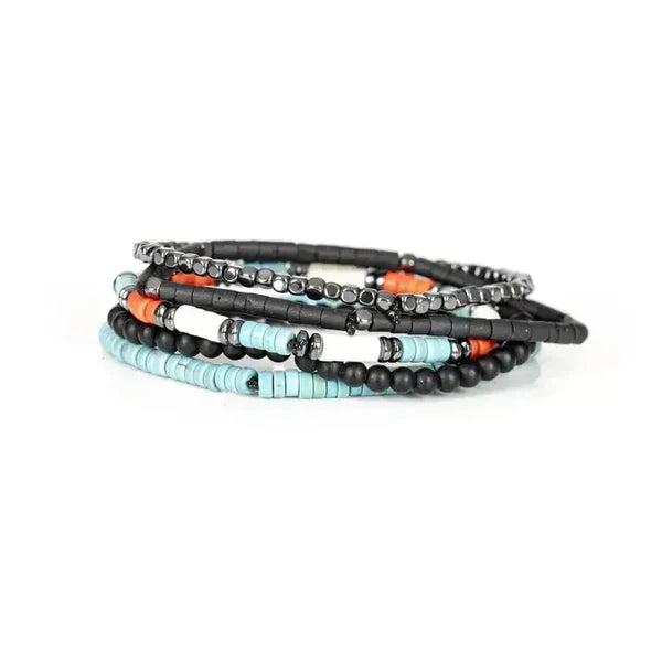 Layered men’s bracelet set featuring turquoise heishi beads, black matte beads, orange accent beads, and silver-tone hematite beads on elastic strands, displayed on a white background