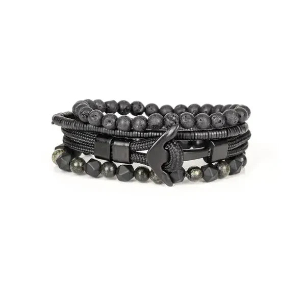 Layered men’s bracelet set featuring black lava stone beads, faceted black stone beads, braided black cord wraps, and metallic hematite accents in a monochromatic stacked design, displayed on a white background.