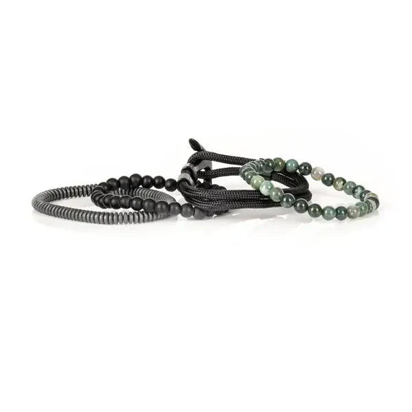 Layered men’s bracelet set featuring green natural stone beads, black matte beads, braided black cord wraps, and matte hematite disc beads, displayed on a white background.