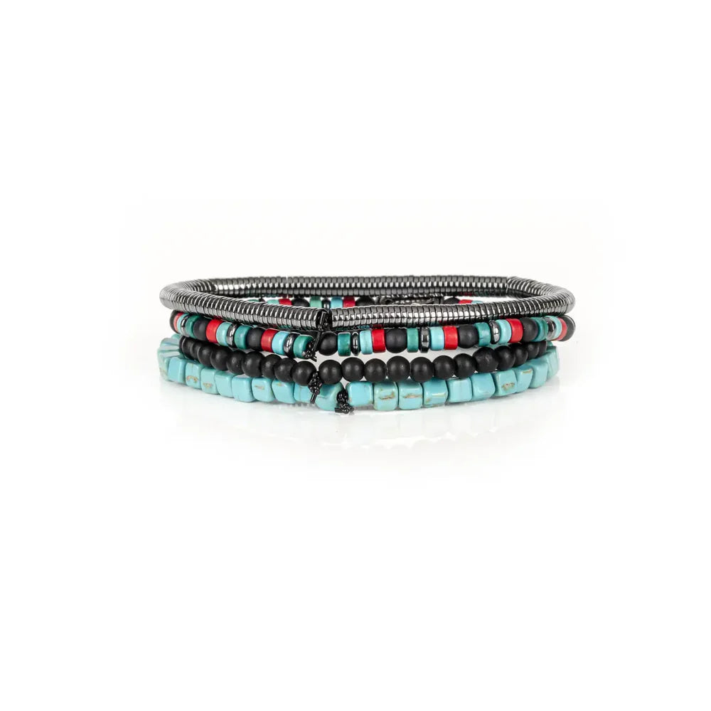 Layered men’s bracelet set featuring turquoise cube beads, black matte stone beads, silver-tone hematite beads, colorful accent beads, and a crystal pavé bat centerpiece, displayed on a white background.