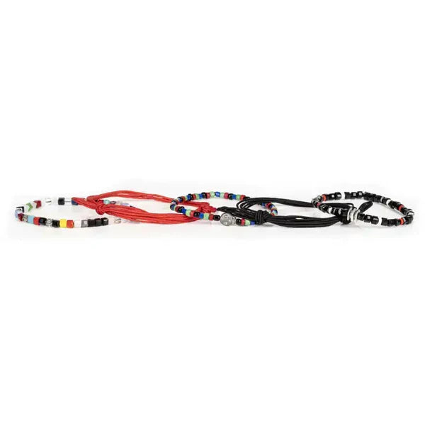 Layered men’s bracelet set featuring black and coral braided cord bracelets, multicolor bead accents, black faceted beads, and a silver-tone skull centerpiece, displayed on a white background.