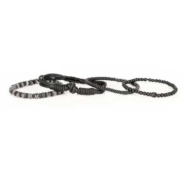 Men's layered black bracelet set featuring matte black beads, natural gray stone beads, braided leather cords, black wood beads, and hematite spacers in a rugged contemporary luxury design.