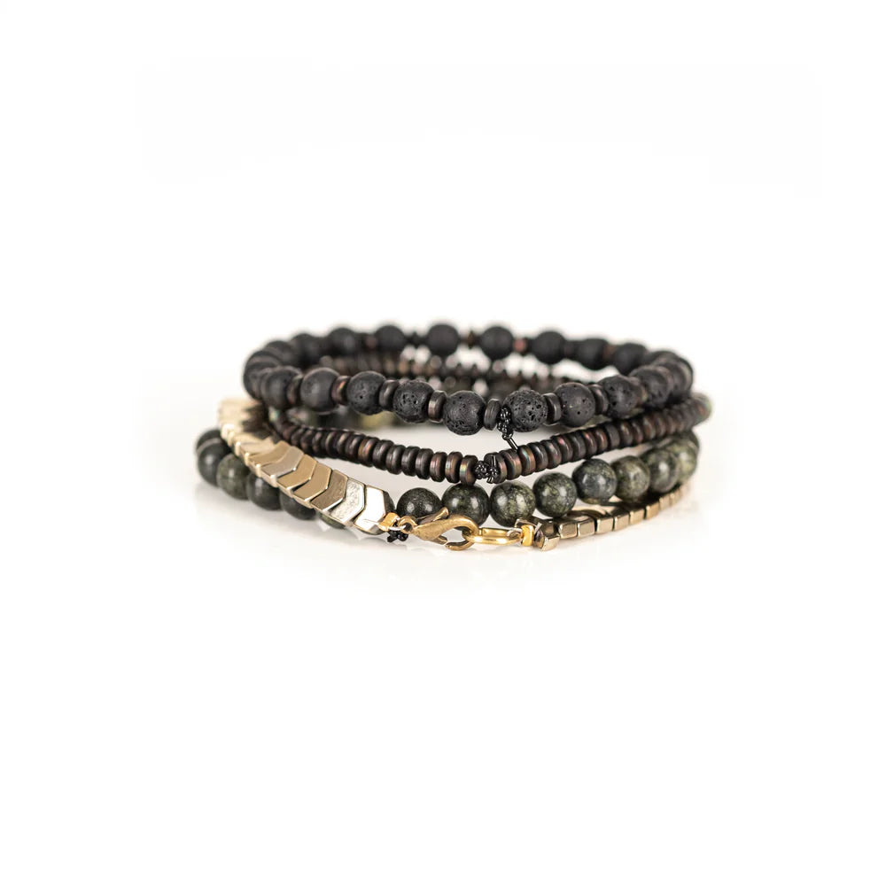 Men's handcrafted layered bracelet set featuring black lava stone beads, natural green serpentine gemstone beads, bronze hematite spacer beads, and gold hematite arrow-shaped beads. Premium stacked men's bracelet photographed on a clean white background.