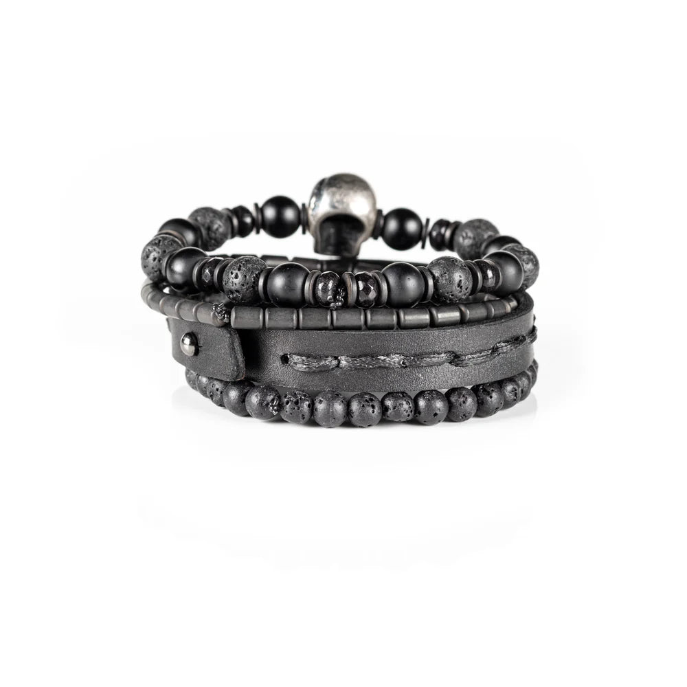 Men's handcrafted black leather wrap bracelet set featuring matte black onyx beads, natural lava stone beads, hematite accents, and a silver skull centerpiece. Premium layered men's bracelet stack photographed on a clean white background.