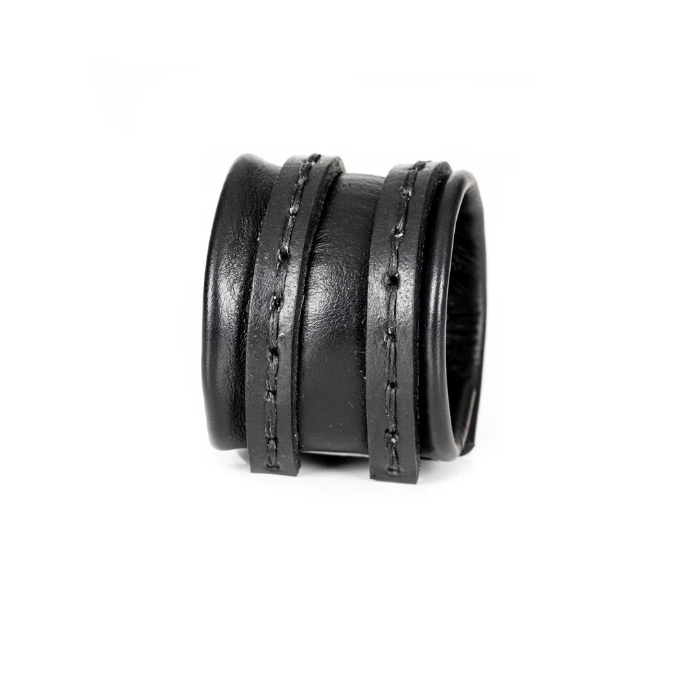 Black genuine leather cuff bracelet with a wide padded center band and hand-stitched wrap straps, handcrafted minimalist statement accessory on a white background.