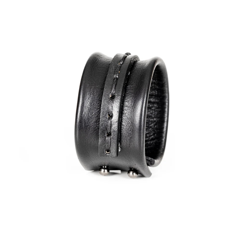 Black genuine leather cuff bracelet with a sculpted padded design, hand-stitched wrap strap detail, and handcrafted artisan finish on a white background.