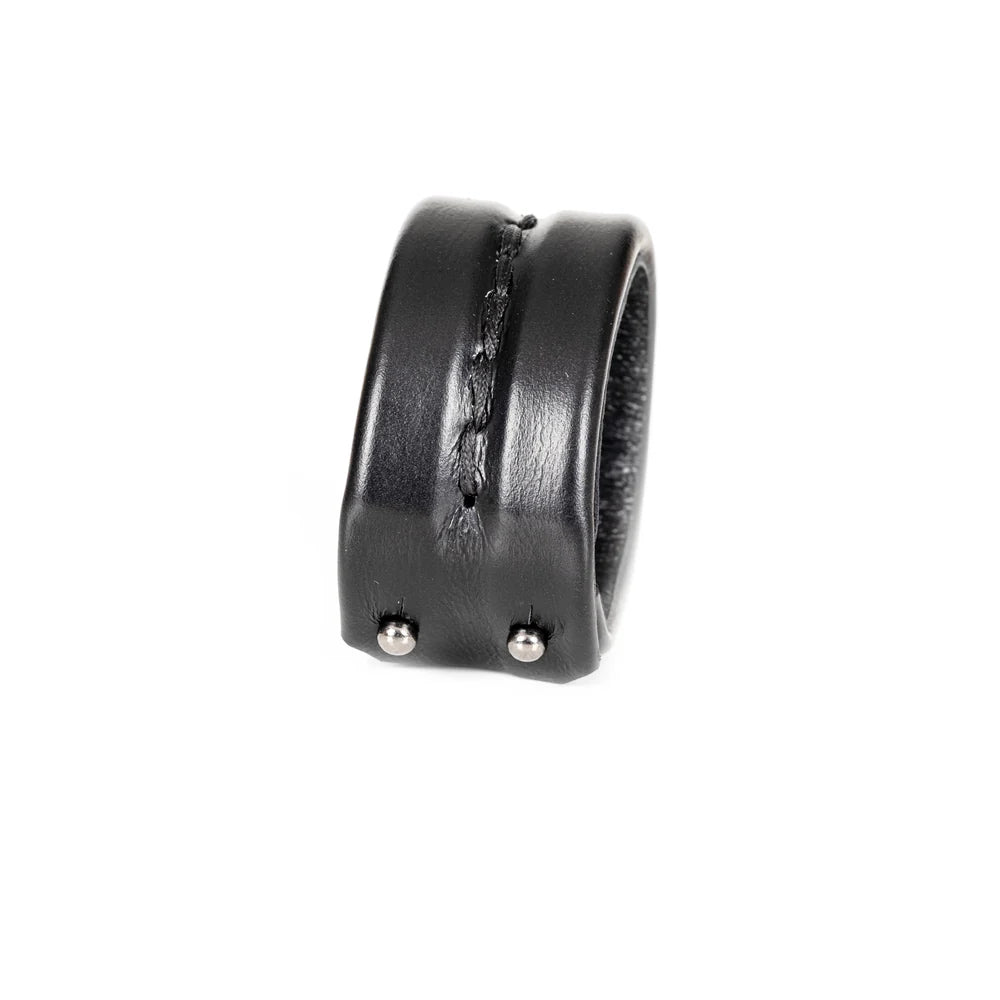 Black genuine leather cuff bracelet with a wide padded silhouette and handcrafted center stitching detail, minimalist statement accessory on a white background.