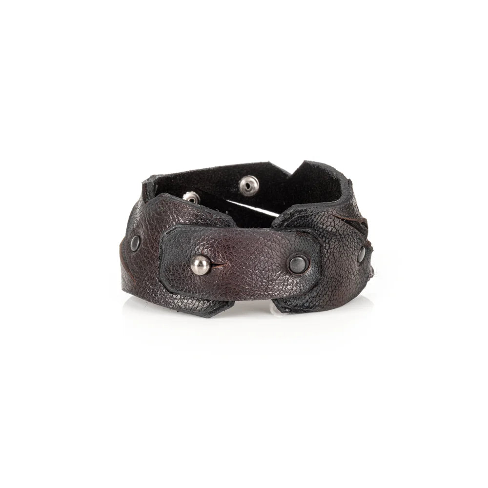 Black genuine leather cuff bracelet with sculpted cutout detailing, black rivet accents, and a handcrafted rugged artisan design, displayed on a white background.