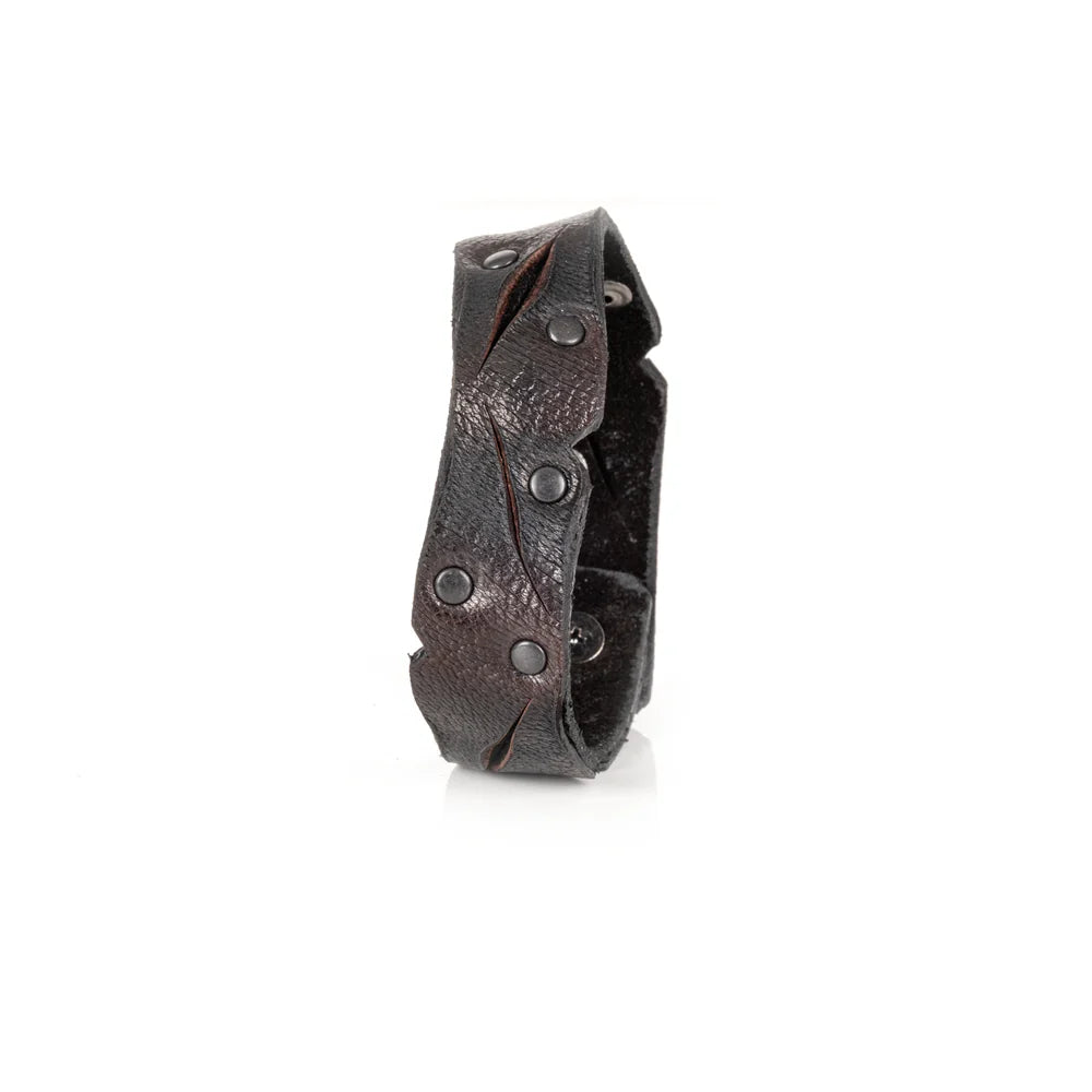 Black genuine leather cuff bracelet with sculpted wave-cut edges, black rivet detailing, and a handcrafted artisan finish, displayed on a white background.