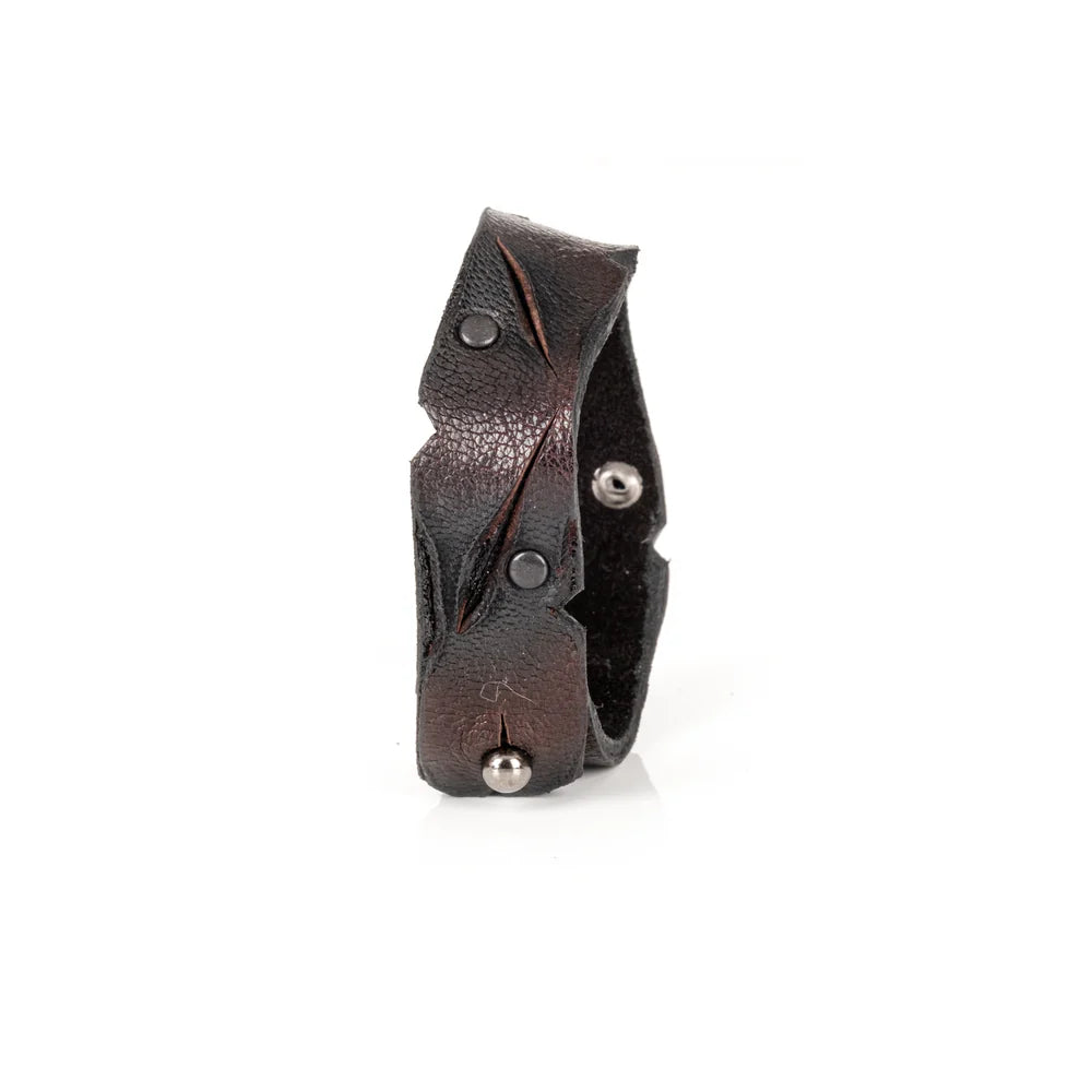 Black genuine leather cuff bracelet with sculpted wave-cut edges, black rivet detailing, and a handcrafted artisan finish, displayed on a white background.