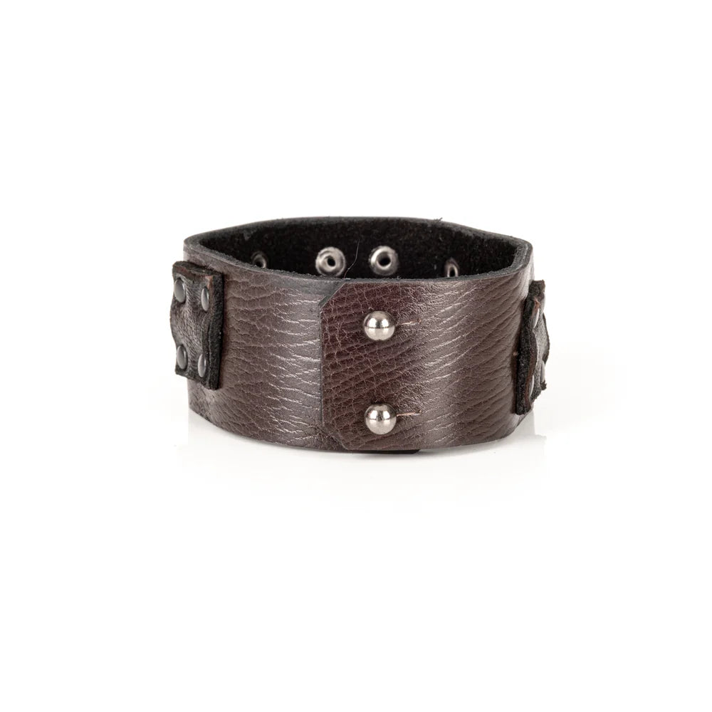 Black genuine leather cuff bracelet with layered square leather panels and black rivet detailing, handcrafted statement accessory with an industrial-inspired design, displayed on a white background.