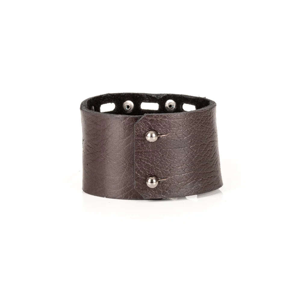 Black genuine leather cuff bracelet with perforated cutout detailing, black rivet accents, and a wide handcrafted statement design, displayed on a white background.