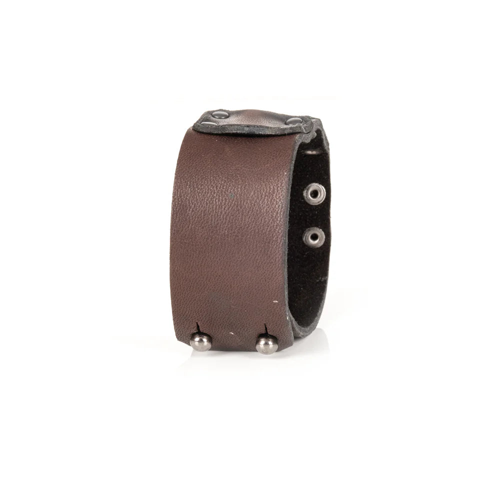 Men's handcrafted genuine leather cuff bracelet in dark brown featuring a wide minimalist design with layered leather panels, matte black rivet detailing, and premium artisan craftsmanship. Luxury men's leather wristband photographed on a clean white background.