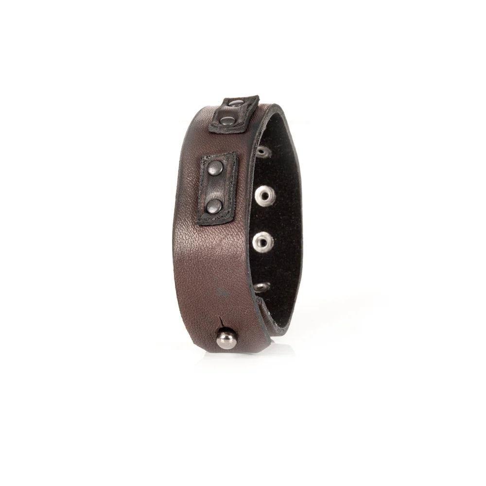 Men's handcrafted genuine leather cuff bracelet in dark brown featuring a wide minimalist design with black leather accent panels, matte black rivet hardware, and premium artisan craftsmanship. Luxury men's leather wristband photographed on a clean white background.