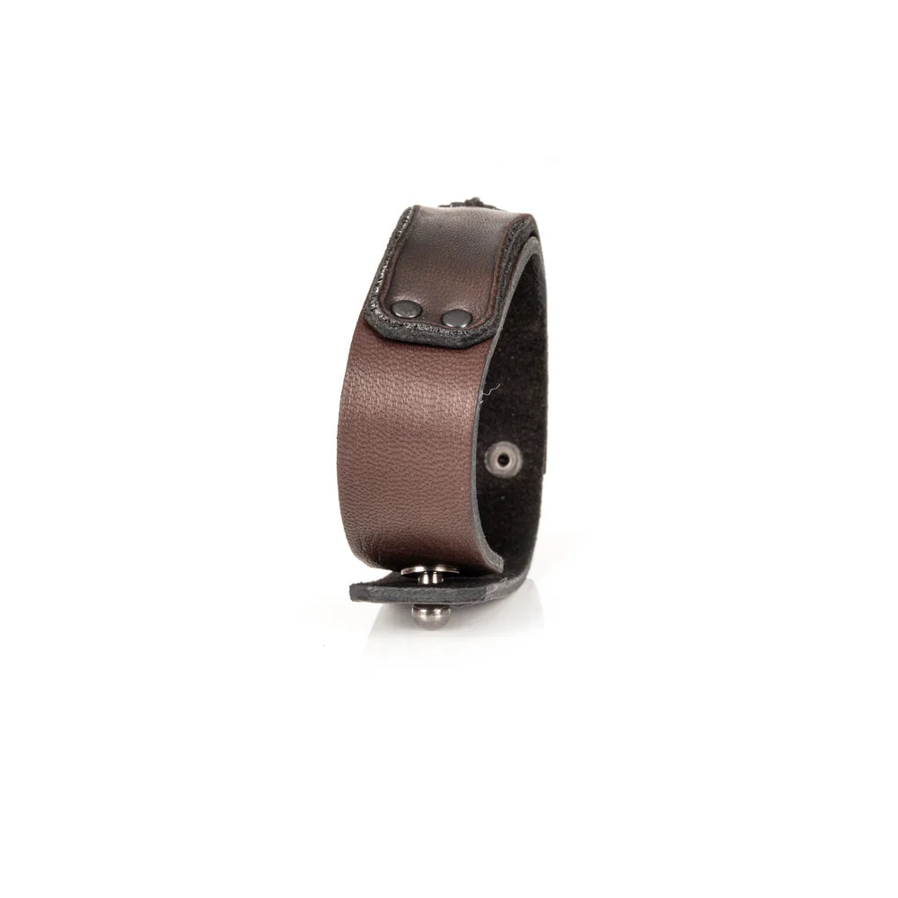 Men's handcrafted genuine leather cuff bracelet in dark brown featuring a wide minimalist design with black rivet hardware, hand-stitched razor blade accent, and premium artisan craftsmanship. Luxury men's leather wristband photographed on a clean white background.